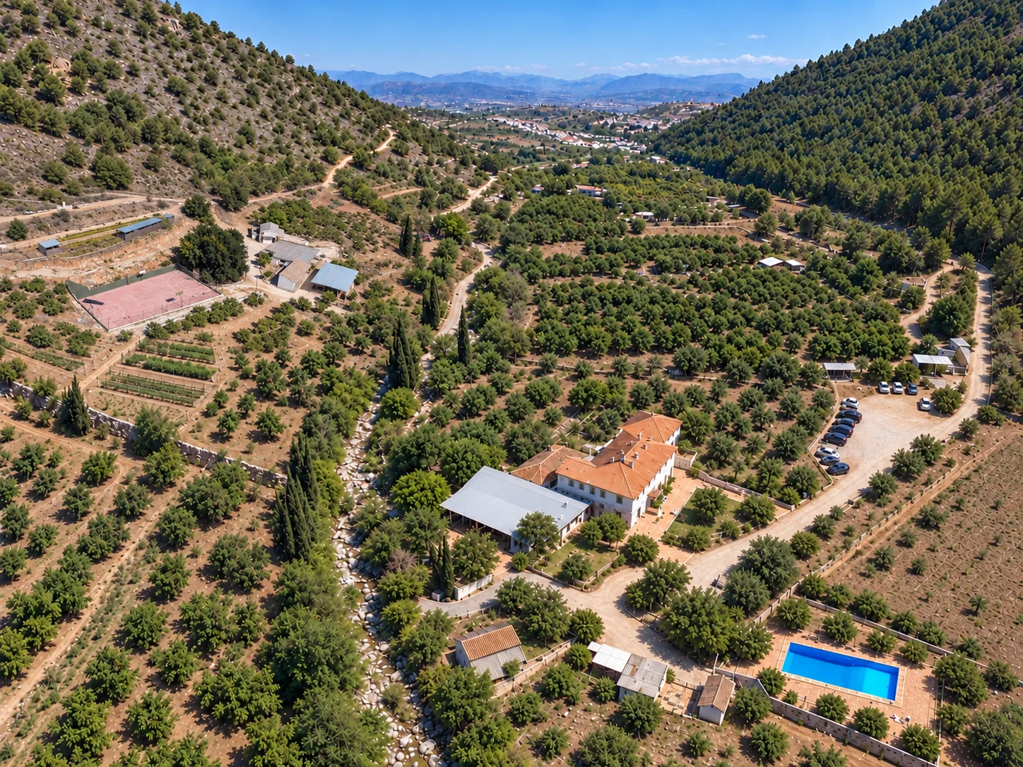 Vista aérea completa de Hacienda Albuqueria con casa, piscina, aparcamiento y zona de pista deportiva, huerto y cuadras